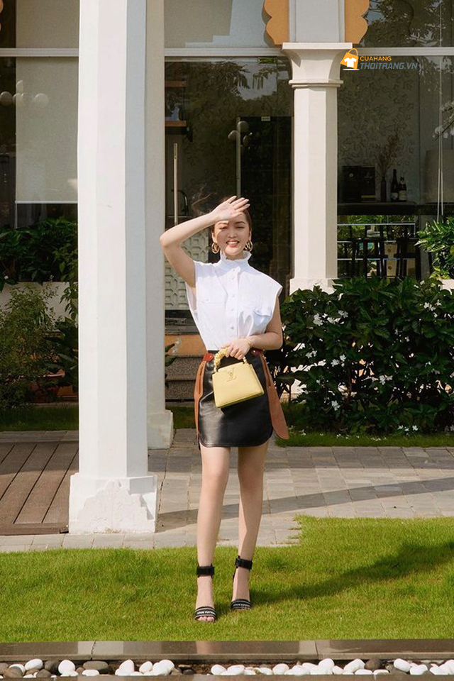 Áo sơ mi trắng cách điệu phối chân váy da sang khiến cô nàng đẹp dịu dàng.