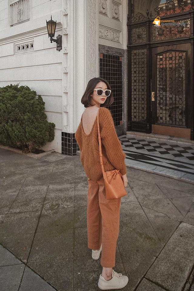 quần kaki nâu kết hợp với áo len khoét vai cùng tông màu. Set đồ tuy đơn giản nhưng rất thời thượng.